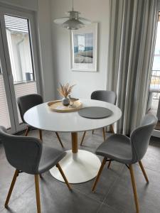 a dining room with a white table and chairs at Ferienhaus SEE & Ferienhaus SEEBLICK in Neukieritzsch