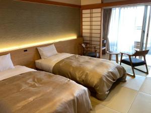 una habitación de hotel con 2 camas y una silla en Natural Farm City Noen Hotel, en Chichibu
