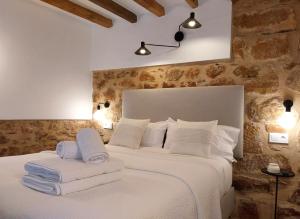 een slaapkamer met een wit bed en handdoeken bij Alojamientos rurales Arbonaida in Baños de la Encina