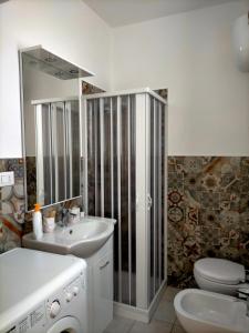 ein Badezimmer mit einem Waschbecken, einem WC und einem Spiegel in der Unterkunft Holiday House Chiara in SantʼAntìoco