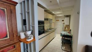 kuchnia z białymi szafkami i blatem w obiekcie 20 Rue Châtel w mieście Verdun