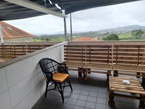 einen Balkon mit Bänken und einem Stuhl auf dem Dach in der Unterkunft Leonchic - Guest House com Piscina de Água Salgada in Barcelos