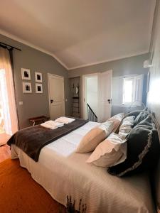 a bedroom with a large bed with white sheets at Castelinho da Azóia - Checkinhome in Sintra