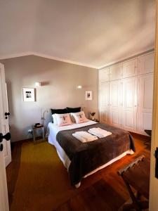 シントラにあるCastelinho da Azóia - Checkinhomeのベッドルーム1室(大型ベッド1台、白いキャビネット付)