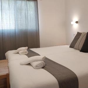Hay dos toallas blancas encima de dos camas. en Mandara - Country Lodging, en Urim