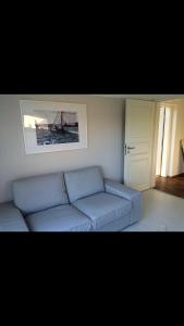 a living room with a blue couch and a picture at Moderne Ferienwohnung in Strandnähe in Surendorf