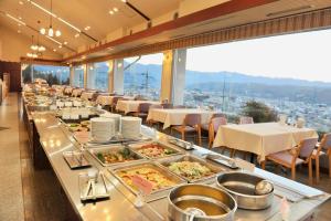 a restaurant with a buffet line with plates of food at Natural Farm City Noen Hotel in Chichibu