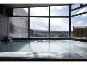 a large swimming pool in a building with a large window at Natural Farm City Noen Hotel in Chichibu