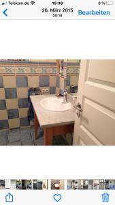 a bathroom with a sink and a bathroom door at Moderne Ferienwohnung in Strandnähe in Surendorf