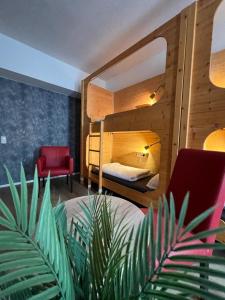 ein Schlafzimmer mit einem Etagenbett und einem roten Stuhl in der Unterkunft Black Sheep in Köln