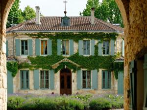 Una entrada a una casa con hiedra. en Château de l'Isle - Chambres d'Hôtes en Castelnau-de-Médoc