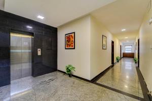 un pasillo de un edificio con una puerta y una planta en OYO Townhouse 1116 US consulate, en Chennai