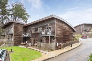 ein Holzhaus mit einem davor geparkten Auto in der Unterkunft House 5 Ironcroft - Modern Pet-friendly, Walk to beach & village in Porthtowan