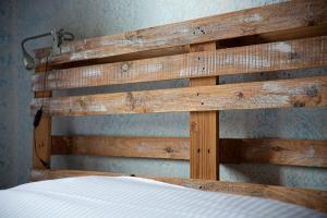 une tête de lit en bois sur un mur avec un lit dans l'établissement CLOS ROYALE Norman's dream, à Asnelles