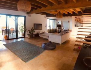 een grote woonkamer met een bank en een tapijt bij La Kase Pouny in Saint-Leu