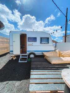 蒂納霍的住宿－Glamping Caravan Lanzarote，停在停车场的白色和蓝色大篷车
