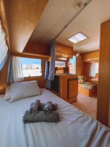 Una cama con dos toallas en una habitación en Glamping Caravan Lanzarote en Tinajo