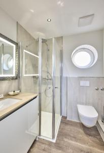 a bathroom with a shower and a toilet and a sink at Janssens Hotel in Neuharlingersiel