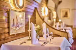 una mesa en un restaurante con un mantel blanco en Janssens Hotel en Neuharlingersiel