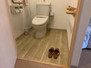 a bathroom with a toilet and a pair of shoes at Natural Farm City Noen Hotel in Chichibu +27 photos