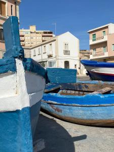 three blue and white boats sitting on the ground at Lakkios charming suites and rooms in Siracusa