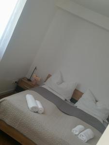 ein weißes Bett mit zwei weißen Handtüchern darauf in der Unterkunft TEREC HAUS in Bruckneudorf
