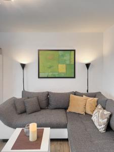 a living room with a couch and a painting on the wall at Schöne helle & gemütliche Wohnung in Altstadtnähe in Erfurt
