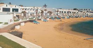 een strand met een stel stoelen en de oceaan bij ON THE BEACH in Costa Teguise