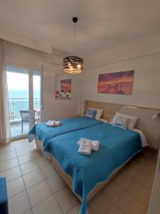 a bedroom with a blue bed with a view of the ocean at KSP Studios in Perea