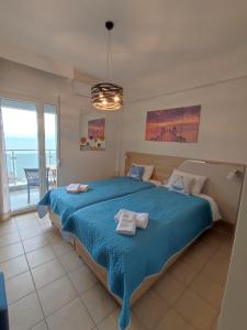 a bedroom with a blue bed with a view of the ocean at KSP Studios in Perea