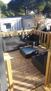a deck with a couch and chairs on it at Amira 6 personnes in Saint-Jean-de-Monts