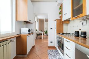 a kitchen with white cabinets and a tile floor at Residence dell'Abbadia by Studio Vita in Bologna