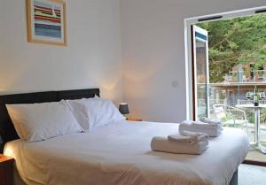 a bedroom with a bed with two towels on it at House 6 Goldcroft - Walk to Beach & Village, Pet-friendly & hottub in Porthtowan