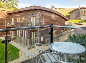 a house with a balcony with a table and chairs at House 6 Goldcroft - Walk to Beach & Village, Pet-friendly & hottub in Porthtowan