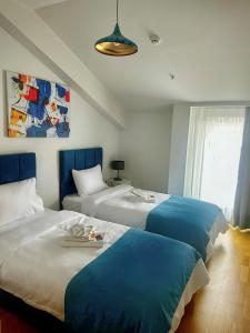 2 letti in una camera con blu e bianco di The Y Istanbul Suites a Istanbul