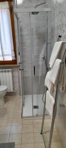 uma casa de banho com um chuveiro e um WC com toalhas em Appartamento a due passi da Piazza del Campo em Siena