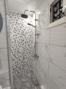 a bathroom with a shower with white tiles at KSP Studios in Perea