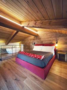 a large bed in a room with a wooden ceiling at AMELU' LOCAZIONI TURISTICHE in Ostana