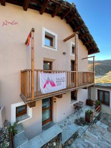 a house with a balcony on the side of it at AMELU' LOCAZIONI TURISTICHE in Ostana