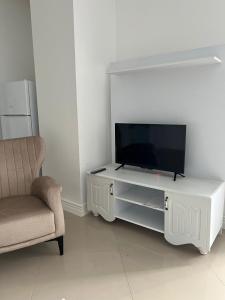 a living room with a tv and a chair at Lägenhet i Yekta Sobieski Development in Alanya