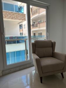 a chair in a room with a large window at Lägenhet i Yekta Sobieski Development in Alanya