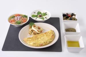a table with a plate of food and bowls of food at Al Khoory Inn Bur Dubai in Dubai