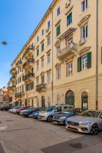 eine Reihe von Autos, die vor einem Gebäude geparkt sind in der Unterkunft Apartments Porto Marina 2 in Rijeka