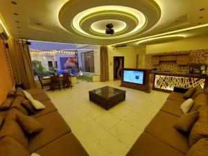 منتجعات نوال في الرياض: غرفة معيشة مع أريكة كبيرة وتلفزيون