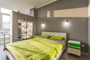 a bedroom with a large bed with green pillows at Gagarin Plaza apartment 70 square metres on 12th floor in Odesa