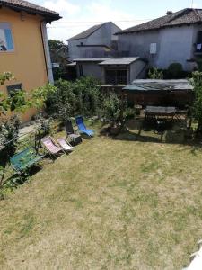 een tuin met stoelen en een picknicktafel en een huis bij Il nido di Simone in Castagnito