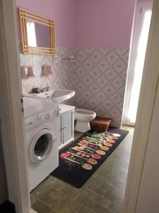 een badkamer met een wasmachine en een wastafel bij Il nido di Simone in Castagnito