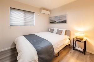 a bedroom with a large white bed and a window at LINKAGE STAY HAKONE YUMOTO in Hakone