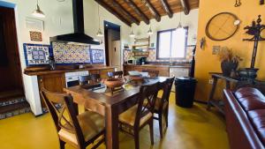 uma cozinha com uma mesa de madeira e cadeiras em Casa Rural Sierra de Aguafría. Finca El Robledillo em Monesterio