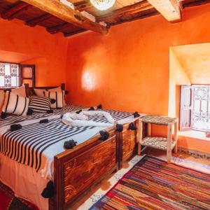 - une chambre avec un grand lit et une fenêtre dans l'établissement Atlas Kasbah Lodge, à Imlil